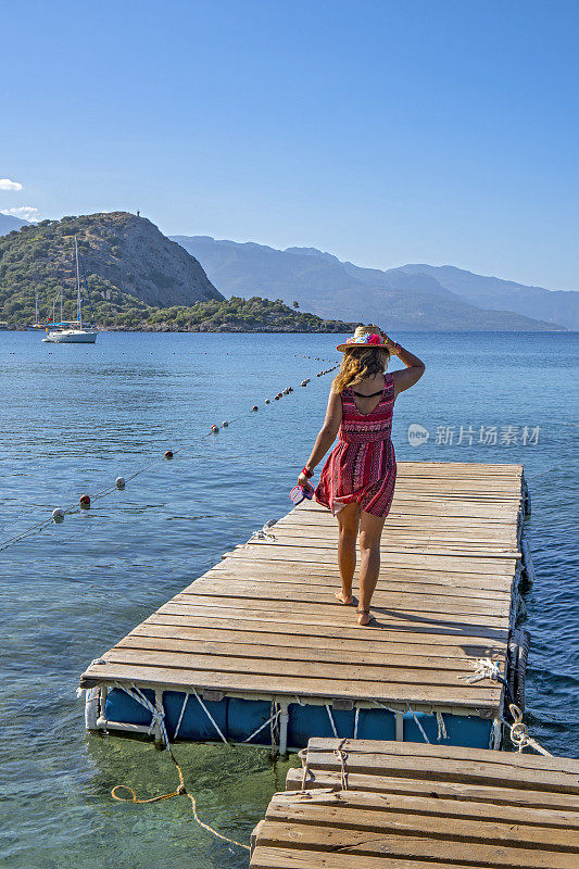 在木栈桥上行走的女人。来自Ölüdeniz, Fethiye，土耳其。